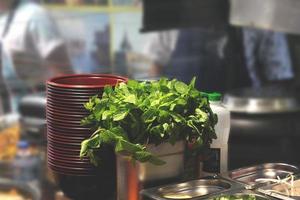 Herbs next to stack of red bowls photo