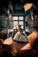 Fantasy fairytale princess in library with flying books photo