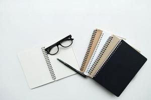 cuadernos con bolígrafo y gafas