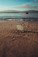 Pedazo de vidrio en la arena de la playa