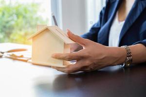 Woman holding wooden house photo