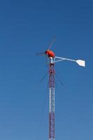 red windmill generates electricity photo