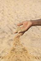 Hombre que sostiene un poco de arena en la mano: sequía y desertificación