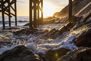 Olas rompiendo en la orilla debajo del muelle foto