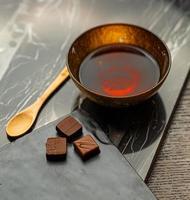 Chocolates next to brown bowl and spoon photo