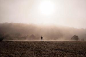 Silhouette Of Person Walking on Brown Field photo