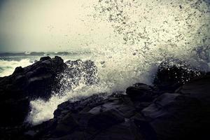 Olas del océano rompiendo contra las rocas durante el día foto