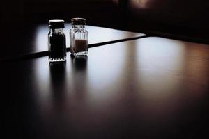 Salt and pepper jars on table photo