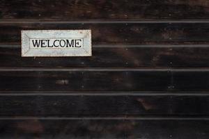 Welcome sign on wooden background photo