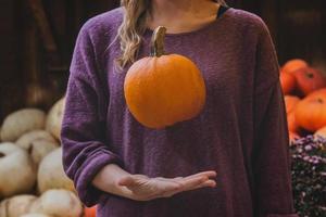 mujer cogiendo calabaza naranja foto