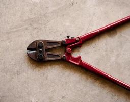 Red bolt cutter on floor photo