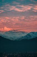 Snow covered mountain under sunset clouds photo