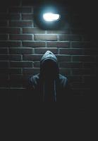 Person in hoodie in the dark photo