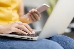 Woman using phone and laptop photo