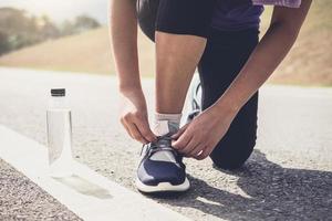 Estilo de vida saludable, corredor atar zapatillas para correr preparándose para la carrera en la pista de atletismo concepto de bienestar de entrenamiento