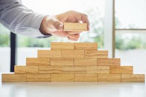 Hand of man is stacking a wooden block photo