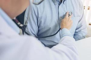 Close up of doctor listening to patient's heartbeat  photo