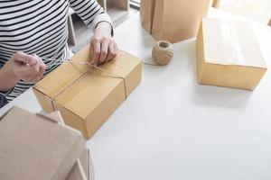 mujer joven vendedora preparando paquete foto