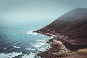 Mountains beside road and sea photo