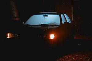 coche viejo con luz brillando a través de las ventanas foto