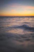 primer plano de las olas del mar durante la puesta de sol foto