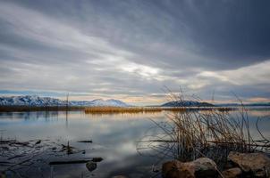 lago cerca de las montañas al atardecer foto