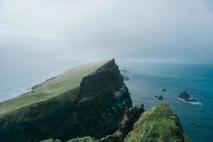 Cliff near ocean under foggy sky
