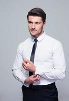 Handsome businessman buttoning shirt photo