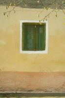 Green window on the orange colored vintage village house photo