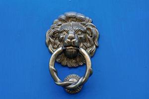 lion head door knocker on a blue door photo
