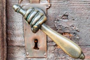 Vintage hand shaped doorknob on antique door, background photo