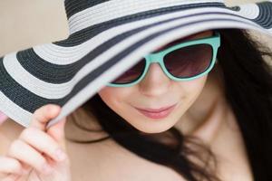Young brunette in turqoise sunglasses photo