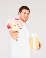 man holding bouquet of flowers and gift box photo