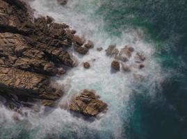 Long-exposure of waves splashing on rocks photo