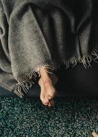 View of person's feet under blanket