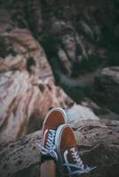 Close-up of low-top sneakers near a cliff photo