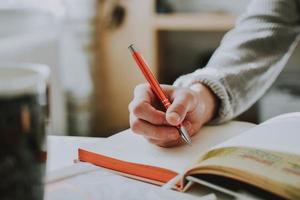 Close-up of person writing in book photo