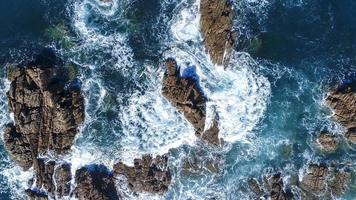 las olas del mar se estrellan contra las rocas foto