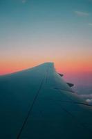 Airplane wing against colorful clear sky photo