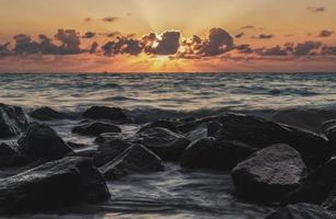 playa rocosa al atardecer foto