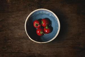 Cerezas rojas en un recipiente sobre la mesa de madera foto