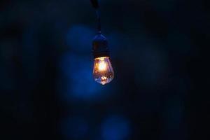 Vintage light bulb in dark room photo