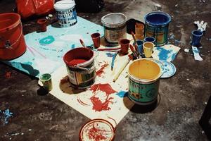 latas de pintura, pinceles y lienzos foto