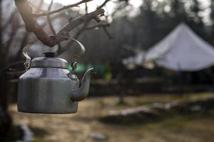 Kettle hanging on branch photo