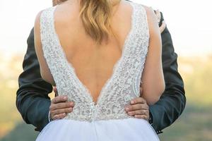 Groom holding bride's waist photo