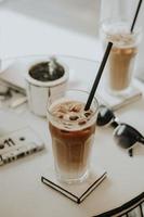 Iced latte with sunglass on a table photo