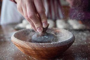 Close-up of person using wooden mortar and pestle