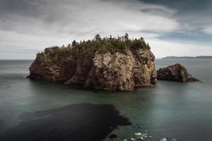 Brown rock formation in body of water photo