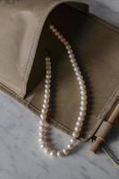 White pearl necklace in textile bag photo