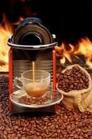 Máquina de café con taza de café espresso junto a la chimenea